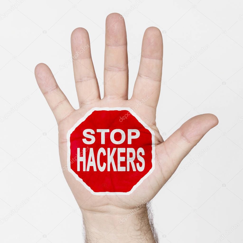 On the palm of the hand there is a stop sign with the inscription - STOP HACKERS. Isolated on white background.