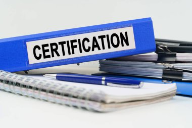 İş ve finans kavramı. Masanın üzerinde bir defter, bir kalem, belgeler ve üzerinde yazı olan bir klasör var.