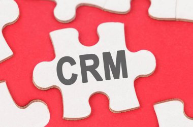 İş ve Ekonomi. Kırmızı arka planda, beyaz bulmacalar arasında bir bulmaca yatıyor - CRM