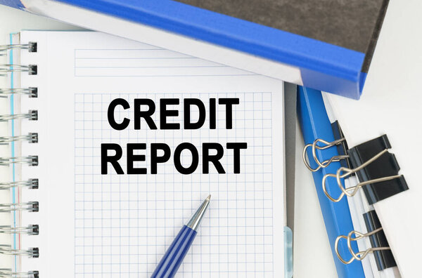 Бизнес и экономика. Среди документов, папок, ноутбука с надписью - CREDIT REPORT