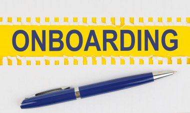 İş ve finans. Masanın üzerinde bir defterden iki sayfa ve sarı arka planda bir kalem var.