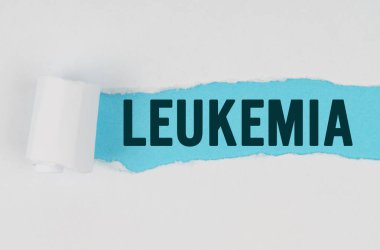 Tıp ve sağlık konsepti. Beyaz bir kağıdın ortasında, altında mavi bir arkaplan olan LEUKEMIA yazısını içeren bir gözyaşı yapılır.