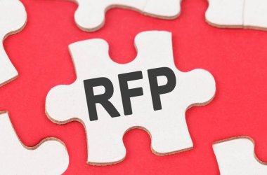 İş ve Ekonomi. Kırmızı arka planda, beyaz bulmacalar arasında RFP yazılı bir bulmaca yatıyor.