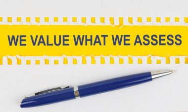 İş ve finans. Masanın üzerinde bir defterden iki yaprak ve sarı arka planda bir kalem var.