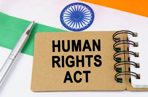 Law and justice concept. Against the background of the flag of India lies a notebook with the inscription - HUMAN RIGHTS ACT