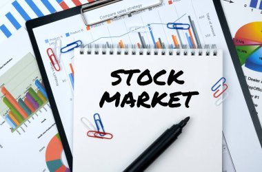 İş ve finans. Masanın üzerinde raporlar, çizelgeler ve üzerinde 