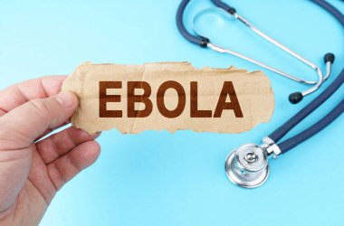 Tıp ve sağlık konsepti. Mavi arka planda, adamın biri üzerinde EBOLA yazan bir karton kutu tutuyor.