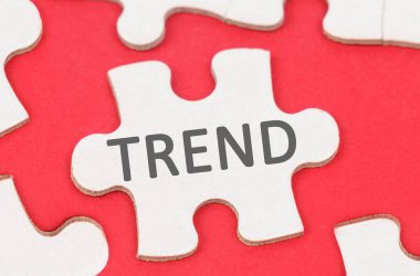 İş ve Ekonomi. Kırmızı bir arkaplanda, beyaz bulmacalar arasında bir bulmaca yatıyor - TREND