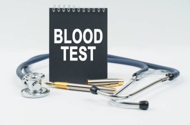 Tıp ve sağlık konsepti. Beyaz arka planda bir stetoskop, bir kalem ve üzerinde 