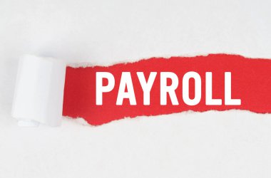 İş ve finans. Kırmızı zemin üzerinde yırtık beyaz kağıt arkasında metin - PAYROLL