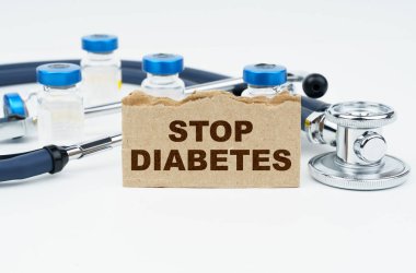 Tıp ve sağlık konsepti. Beyaz bir masada ampuller, bir steteskop ve yazılı bir karton bulunur.