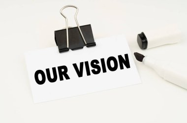 Finans ve iş konsepti. Beyaz arka planda bir işaret ve üzerinde bizim vizyonumuz yazan bir kartvizit var.