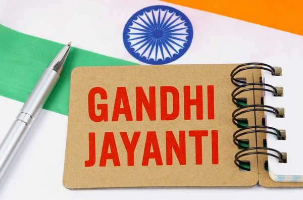 Holidays in India. Against the background of the flag of India lies cardboard with the inscription - Gandhi Jayanti