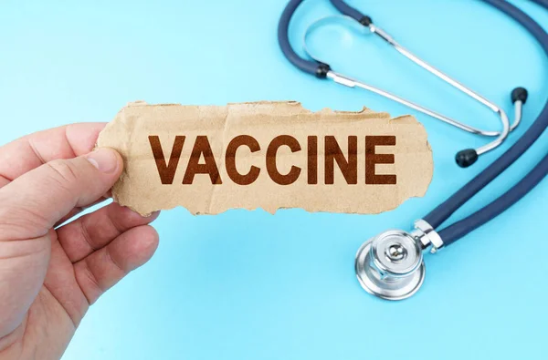 医学と健康の概念 青の背景に 男は碑文と段ボール箱を保持しています Vaccine — ストック写真