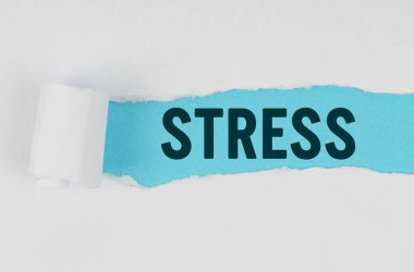 Tıp ve sağlık konsepti. Beyaz bir kağıt parçasının ortasında, altında mavi bir arkaplan olan STRESS yazısını içeren bir gözyaşı yapılır.