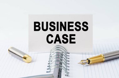 Finans ve iş konsepti. Masanın üzerinde bir defter, bir kalem ve bir kartvizit var. Üzerinde 