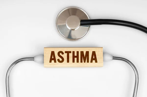 Health and medicine concept. On the table is a stethoscope and a wooden plate with the inscription - Asthma