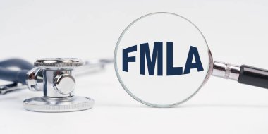 Medicine and health concept. There is a stethoscope on the table, a magnifying glass with the inscription - FMLA clipart