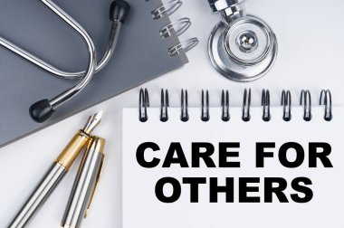 Tıp ve sağlık konsepti. Masanın üzerinde bir steteskop, bir kalem ve bir defter var.