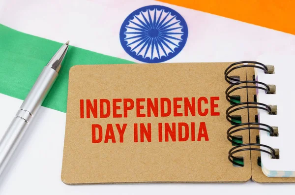 Holidays in India. Against the background of the flag of India lies cardboard with the inscription - Independence Day in India