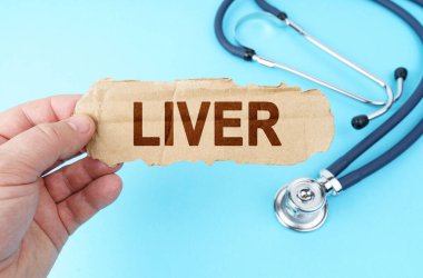 Medicine and health concept. On a blue background, a man holds a cardboard box with the inscription - LIVER