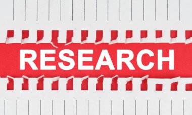 Business and law concept. Between two sheets of notebook on a red background the inscription - RESEARCH