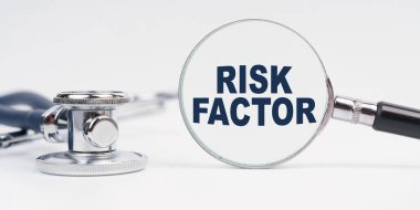 Medicine and health concept. There is a stethoscope on the table, a magnifying glass with the inscription - RISK FACTOR