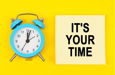 İş ve finans kavramı. Sarı arka planda bir saat ve üzerinde yazı olan bir etiket var.