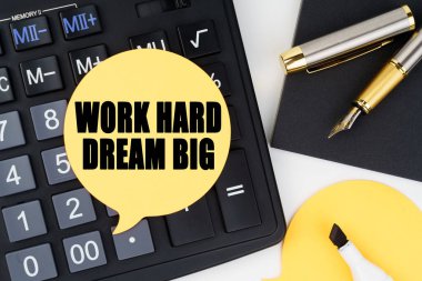 İş ve ekonomi kavramı. Bir hesap makinesi, bir kalem, bir keçeli kalem ve bir çıkartma var. Üzerinde 