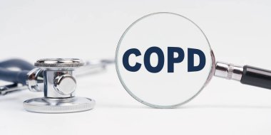 Tıp ve sağlık konsepti. Masanın üzerinde steteskop var, üzerinde COPD yazan bir büyüteç.