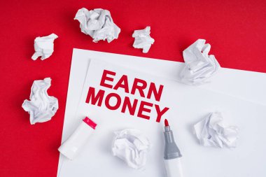 İş ve finans kavramı. Kırmızı arka planda buruşmuş bir kağıt, bir kalem ve üzerinde 