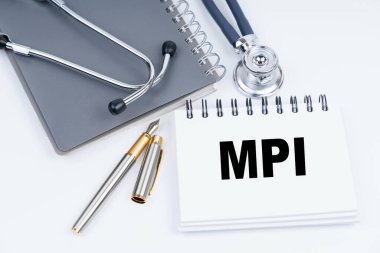 Tıp ve sağlık konsepti. Masanın üzerinde bir steteskop, bir kalem ve üzerinde MPI yazan bir defter var.