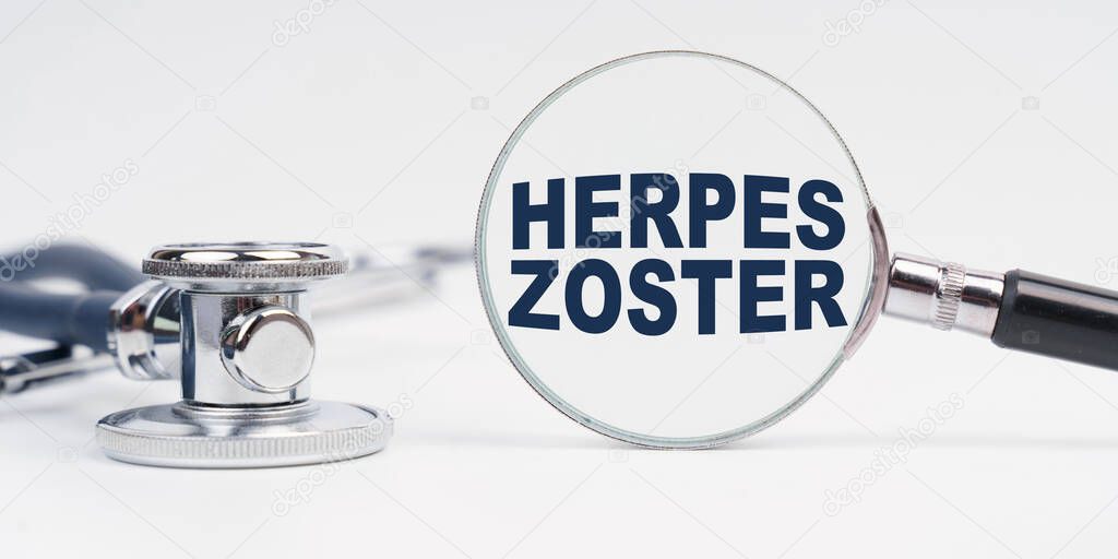 Medicine and health concept. There is a stethoscope on the table, a magnifying glass with the inscription - HERPES ZOSTER