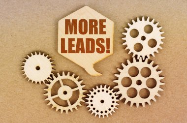 İş ve ekonomi kavramı. Kağıt bir arka planda, dişliler ve üzerinde yazı olan bir düşünce levhası - Daha fazla ipucu