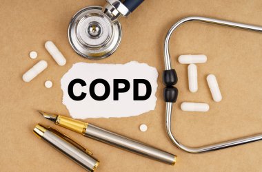 Tıp ve sağlık konsepti. Masanın üzerinde steteskop, haplar, üzerinde COPD yazan bir kalem ve kağıt var.