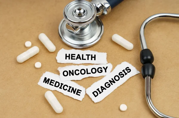 医学和健康概念 桌上放着听诊器 药丸和刻有铭文的纸 — 图库照片