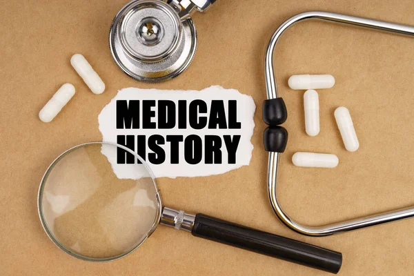 医学和健康概念 桌上放着听诊器 放大镜和印有 医学之门 字样的纸 — 图库照片