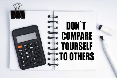 Ekonomi ve finans kavramı. Masanın üzerinde bir işaret, bir hesap makinesi ve üzerinde yazı olan bir defter var. -