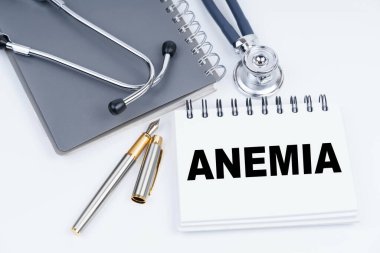 Tıp ve sağlık konsepti. Masanın üzerinde bir steteskop, bir kalem ve üzerinde ANEMIA yazan bir defter var.