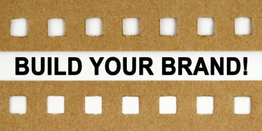 İş ve ekonomi kavramı. Beyaz arka planda delikleri olan çarşafların arasında senin markanı oluşturan yazı var.