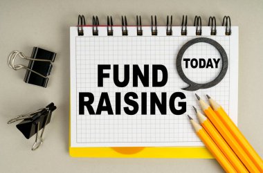 İş ve ekonomi kavramı. Masanın üzerinde kalemler ve üzerinde yazılar olan bir defter var - bugün ve FUND yükseltme