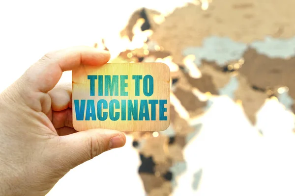 医学と健康の概念 世界地図の背景に 男は碑文とサインを保持しています 予防接種の時間 — ストック写真