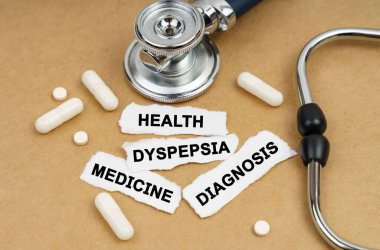 Tıp ve sağlık konsepti. Masanın üzerinde stetoskop, hap ve yazılı kağıt parçaları var - Sağlık, MEDICINE, DIAGNOSIS, DYSPEPSIA