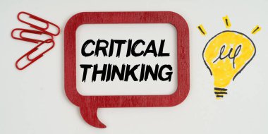 Fikir ve iş kavramı. Kağıt üzerinde, bir lamba çizimi, ataç ve yazılı bir tabela - eleştirel düşünme