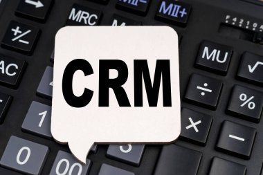 İş ve ekonomi kavramı. Hesap makinesinde beyaz bir plaka var, üzerinde de CRM yazıyor.