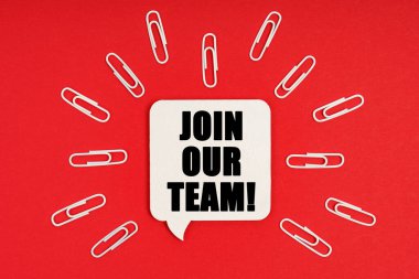 İş ve finans kavramı. Kırmızı arkaplanda ataçlar ve yazılı bir tabela var. Ekibimize katıl.