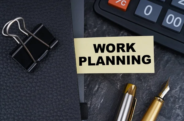 金融和商业概念 桌上有一个计算器 一支钢笔和一个笔记本 笔记本上有书签 上面写着工作计划 — 图库照片