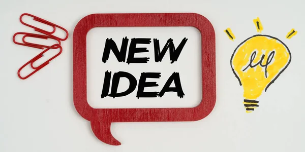 アイデアやビジネスコンセプト 紙には ランプ 紙クリップの図面と碑文付きの記号 新しいアイデア — ストック写真
