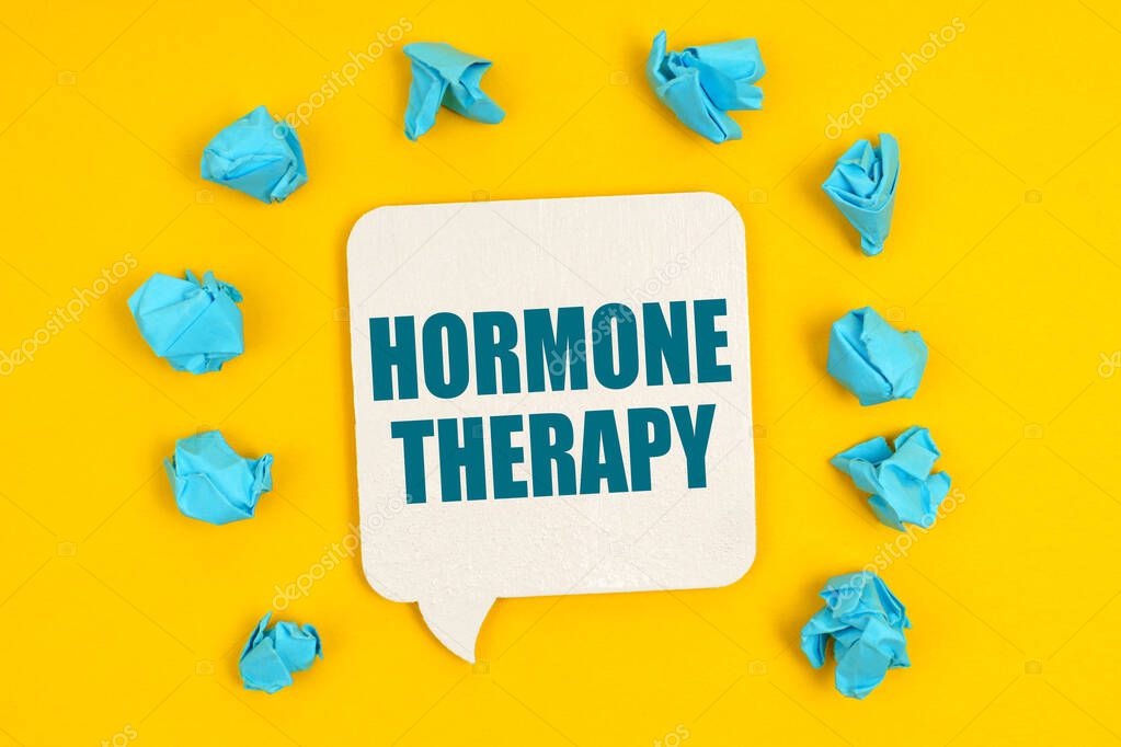 Medicine concept. On a yellow background, blue pieces of paper and a sign with the inscription - HORMONE THERAPY