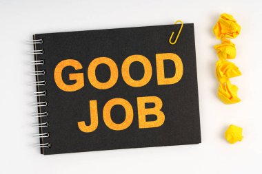 İş konsepti. Beyaz arka planda bir işaret, kağıttan yapılmış bir ünlem işareti ve üzerinde yazı olan bir defter var.